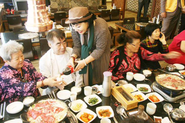 탤랜트 이숙씨가 어르신들에게 음식을 대접해드리고 있다.