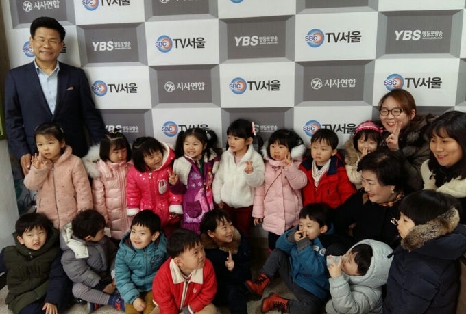 김용숙 대표이사가 푸른숲 어린이집 원생들과 기념촬영을 하고 있다. 