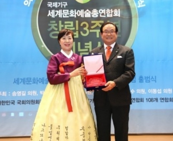 박수정 연합회 가수협회 수석 상임부회장이 한장석 이사장으로 부터 공로패를 받고 있다.