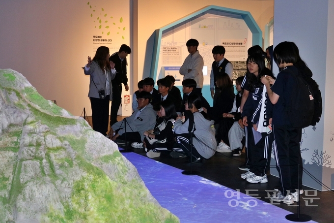 학생들이 해설사의 설명을 들으며 독도조형물을 관람하고 있다.